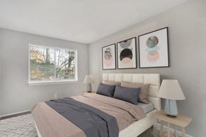 Falls Church apartment for rent - A bedroom with a large bed and three framed pictures on the wall.