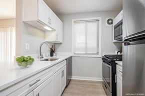 Falls Church apartment for rent - A kitchen with white cabinets and a stainless steel refrigerator.