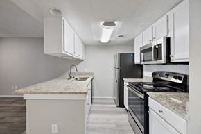 Dallas apartment for rent - A kitchen with white cabinets and a granite countertop.
