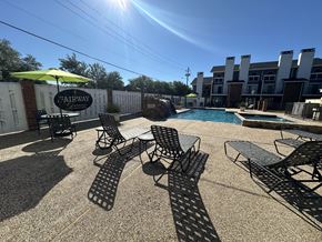 Dallas apartment for rent - A pool area with chairs and a sign that says Fairway.