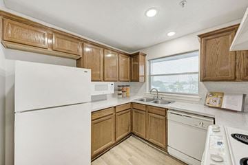 Austin apartment for rent - A kitchen with wooden cabinets and white appliances.