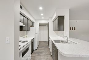 Austin apartment for rent - A kitchen with wooden cabinets and white appliances.