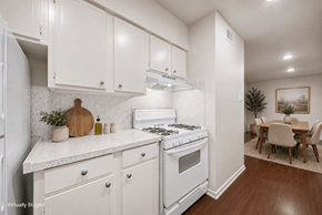 Austin apartment for rent - A white kitchen with a stove and a dining table.