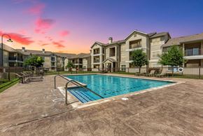 Pflugerville apartment for rent - A large swimming pool in front of apartment buildings.