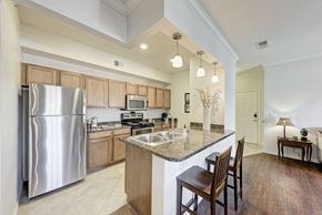 Pflugerville apartment for rent - A modern kitchen with a large island and wooden cabinets.