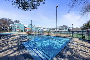Austin apartment for rent - A blue swimming pool with a metal ladder on the left side.
