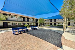 Las Vegas apartment for rent - A courtyard with benches and a building in the background.