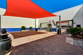 Las Vegas apartment for rent - A red shade structure is over a brick walkway.
