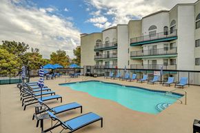 Las Vegas apartment for rent - A swimming pool surrounded by sun loungers and apartment buildings.