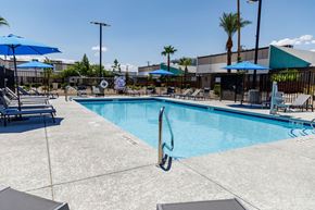 Las Vegas apartment for rent - A pool with a diving board and sun loungers.