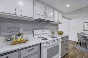 Las Vegas apartment for rent - A modern kitchen with a white stove top oven and a wooden cutting board with lemons on it.