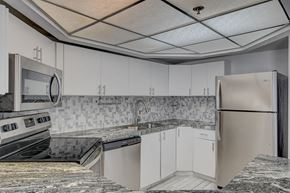 Las Vegas apartment for rent - A kitchen with white cabinets and a granite counter top.