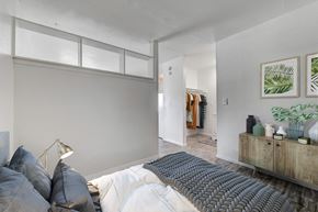 Las Vegas apartment for rent - A bedroom with a bed, pillows, a lamp, and a wooden cabinet.