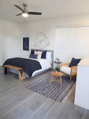 Las Vegas apartment for rent - A bedroom with a bed, a bench, and a rug.