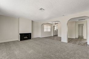Las Vegas apartment for rent - A spacious living room with a fireplace and a ceiling fan.