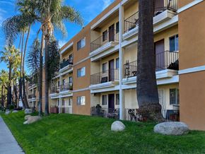 Valley Village apartment for rent - A building with balconies and a palm tree in front.
