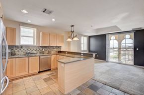 Las Vegas apartment for rent - A kitchen with wooden cabinets and a tiled backsplash.