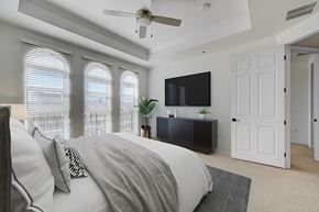 Las Vegas apartment for rent - A bedroom with a bed, a television, and a ceiling fan.