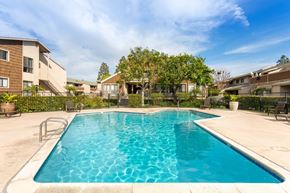 Costa Mesa apartment for rent - A swimming pool in a residential area with houses in the background.