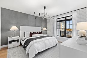 Westbury apartment for rent - A modern bedroom with a large bed and a balcony.