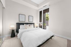 Toronto apartment for rent - A bedroom with a large bed and two nightstands with lamps.