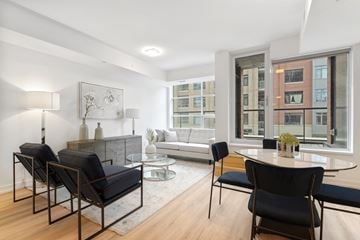 Ottawa apartment for rent - A living room with a black chair and a glass table.