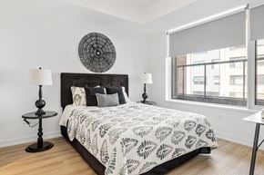 Ottawa apartment for rent - A bedroom with a large bed and a round decorative piece on the wall.