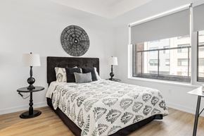 Ottawa apartment for rent - A bedroom with a large bed and a round decorative piece on the wall.