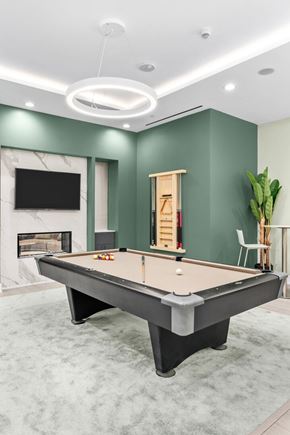 Toronto apartment for rent - A pool table in a room with a fireplace and a TV.