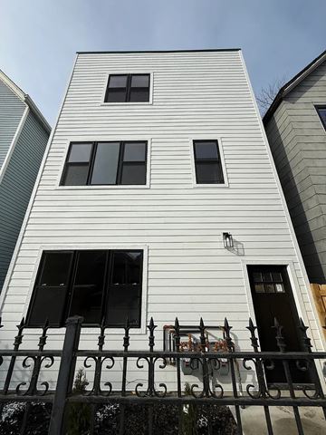 Chicago apartment for rent - A white building with black windows and a black fence.