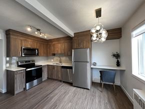 Calgary apartment for rent - A kitchen with wooden cabinets and a stainless steel refrigerator.