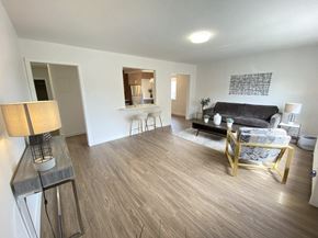 Calgary apartment for rent - A living room with a couch, chair, and lamp.