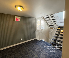 Calgary apartment for rent - A room with a striped wall and a staircase.
