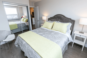 Calgary apartment for rent - A bedroom with a large bed and a chair.