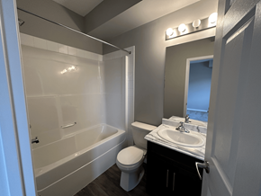 Spruce Grove apartment for rent - A bathroom with a white tub, toilet, and sink.