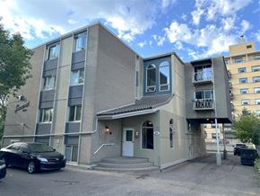 Calgary apartment for rent - A modern two-story building with a parking lot in front.