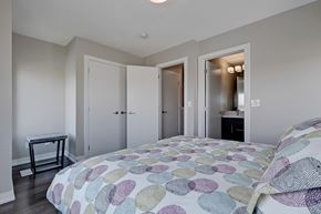 Calgary apartment for rent - A bedroom with a bed and a table.