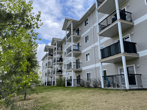 Spruce Grove apartment for rent - Apartment building with balconies and a tree in the foreground.