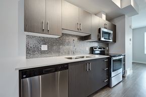 Calgary apartment for rent - A modern kitchen with a stainless steel dishwasher and microwave.