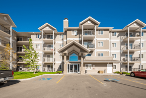 Spruce Grove apartment for rent - A large apartment complex with a parking lot in front.