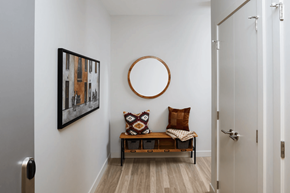 Calgary apartment for rent - A hallway with a bench and a painting on the wall.