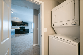 Spruce Grove apartment for rent - A white dishwasher is in a kitchen next to a white door.