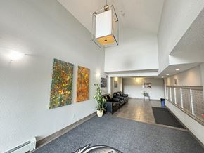 Enoch apartment for rent - A hallway with a grey carpet and a black sofa.