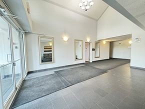 Enoch apartment for rent - A spacious hallway with grey tiled floors and white walls.