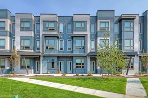 Calgary apartment for rent - A row of modern townhouses with blue doors and windows.