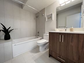 Calgary apartment for rent - A bathroom with a white tub, toilet, and sink.