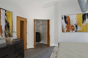 Dayton apartment for rent - Apartment bedroom with a bed and paintings on the wall and hardwood-style flooring