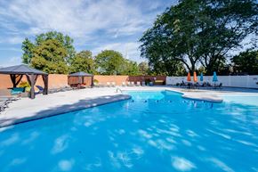 Dayton apartment for rent - Dayton Towers resident swimming pool surrounded by trees and a white fence.