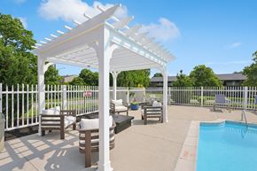 Erlanger apartment for rent - A white pergola is over a patio with a pool.