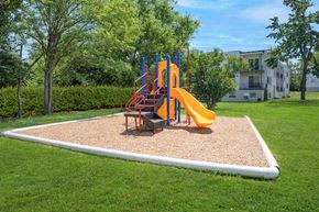 Cincinnati apartment for rent - A playground with a yellow slide and a red and blue structure.